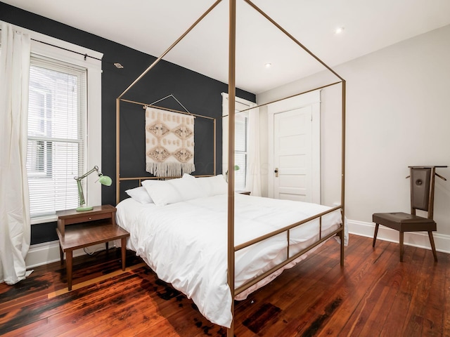 bedroom with dark hardwood / wood-style flooring and a closet