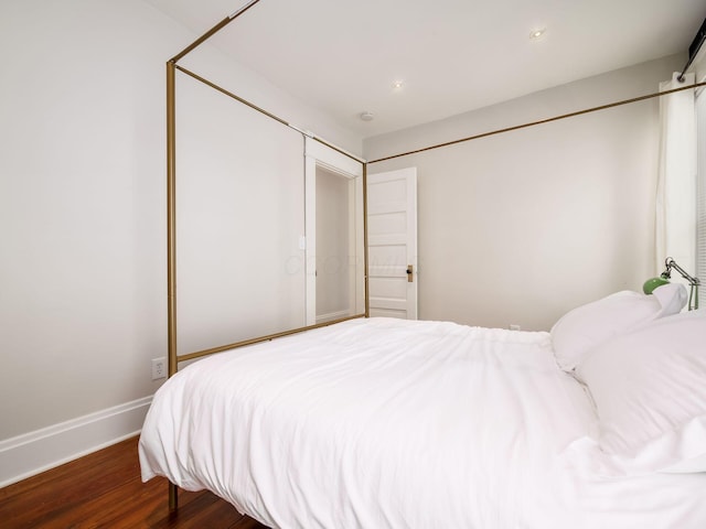 bedroom with dark hardwood / wood-style floors and a closet