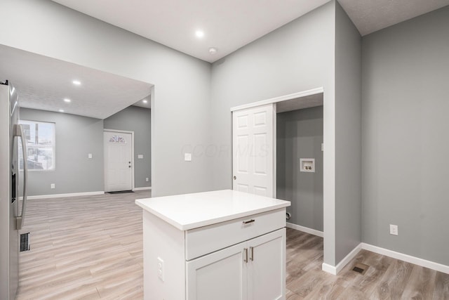 kitchen with light hardwood / wood-style flooring, white cabinets, and stainless steel fridge with ice dispenser