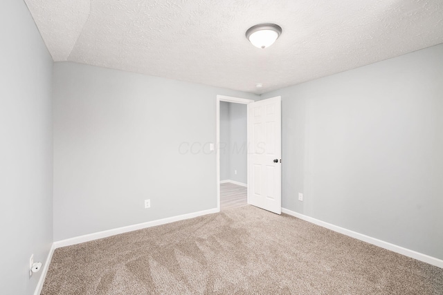 carpeted spare room with a textured ceiling