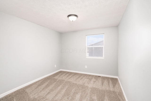 carpeted empty room with a textured ceiling