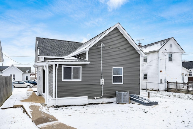 snow covered property with central air condition unit