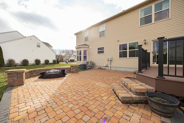 rear view of house with a fire pit, a patio, central AC unit, and a deck