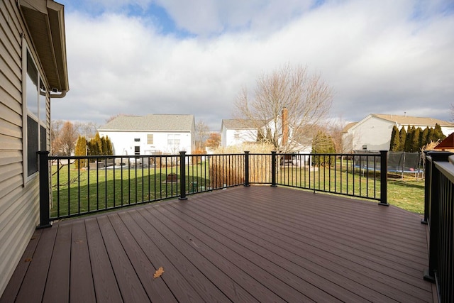 deck featuring a trampoline and a lawn