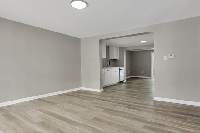 unfurnished living room with sink and light hardwood / wood-style flooring