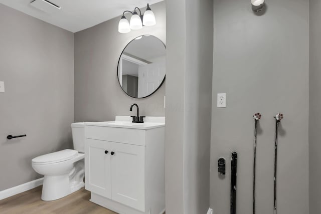 bathroom featuring vanity, toilet, and wood-type flooring