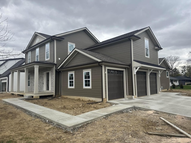 view of side of property featuring an attached garage, a shingled roof, a porch, and concrete driveway