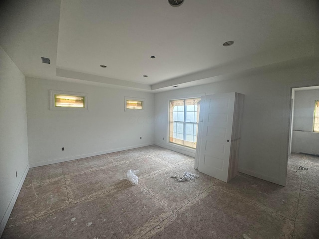 empty room with visible vents, baseboards, and a raised ceiling
