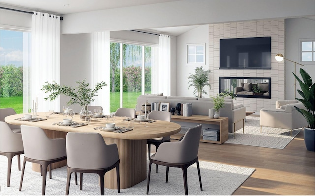 dining space featuring vaulted ceiling, wood finished floors, and plenty of natural light