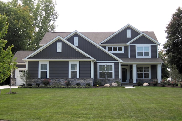 craftsman inspired home with stone siding, a shingled roof, and a front lawn