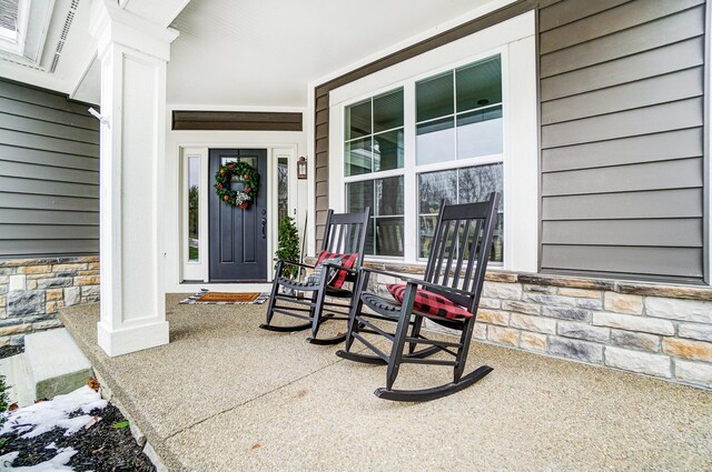 property entrance featuring stone siding and a porch