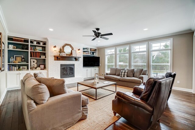 living area with baseboards, ornamental molding, dark wood-style flooring, and a healthy amount of sunlight