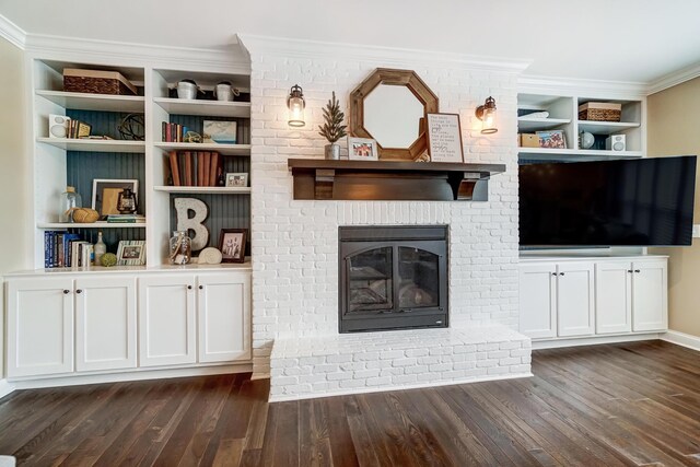 unfurnished living room with a brick fireplace, dark wood finished floors, and crown molding