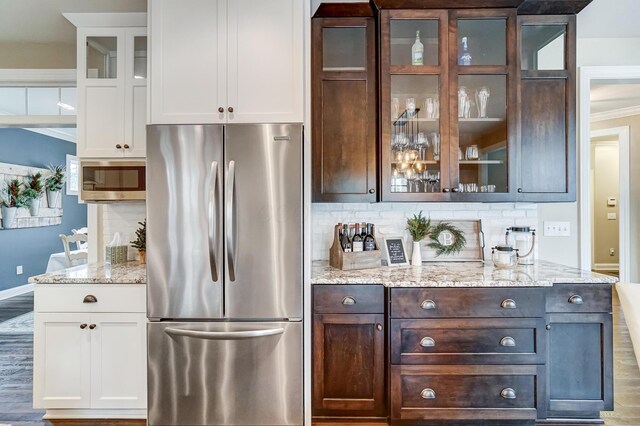 bar featuring crown molding, baseboards, stainless steel appliances, and backsplash