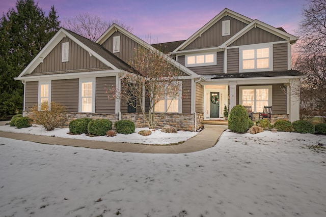 craftsman-style home featuring board and batten siding, stone siding, and a porch