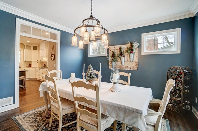 dining area featuring dark wood-style flooring, visible vents, crown molding, and baseboards