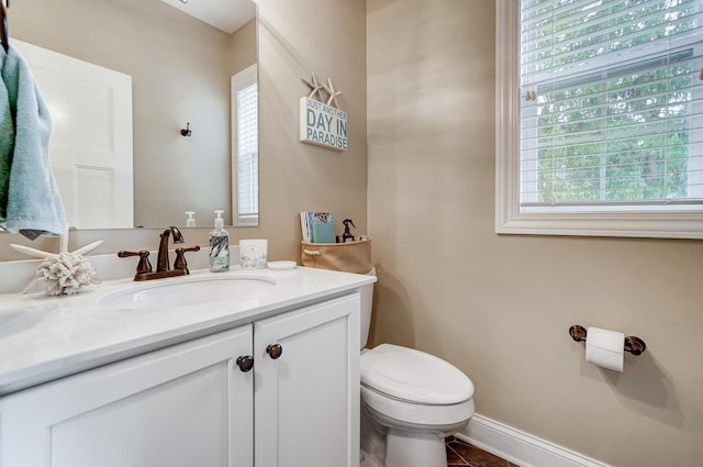 bathroom with tile patterned flooring, vanity, toilet, and baseboards