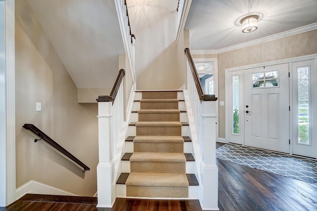 foyer entrance with ornamental molding, dark wood-style flooring, and baseboards