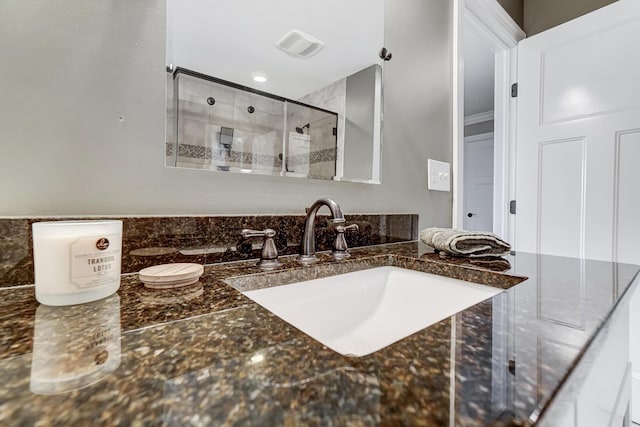 full bathroom featuring a stall shower, vanity, and visible vents