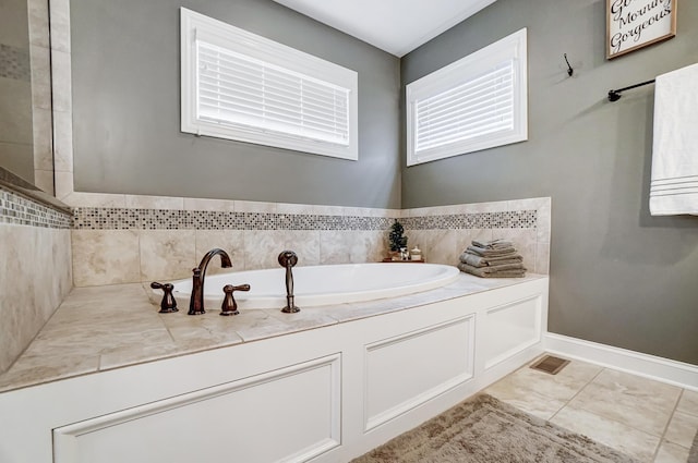 bathroom featuring tile patterned floors, visible vents, baseboards, and a bath