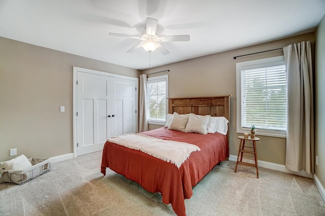 bedroom featuring multiple windows, baseboards, and light colored carpet