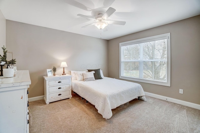 bedroom with light carpet, ceiling fan, and baseboards