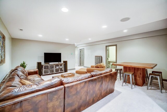 living area with recessed lighting, visible vents, and light colored carpet