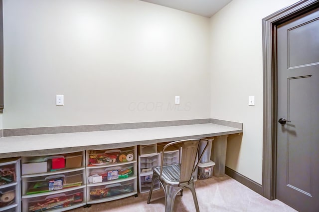 interior space featuring built in desk and carpet flooring