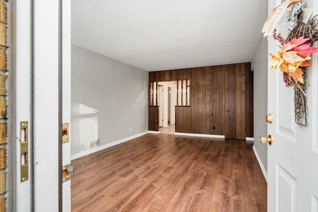 entryway with wood walls and wood-type flooring