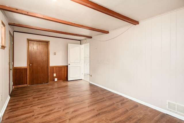 spare room with hardwood / wood-style flooring and beam ceiling