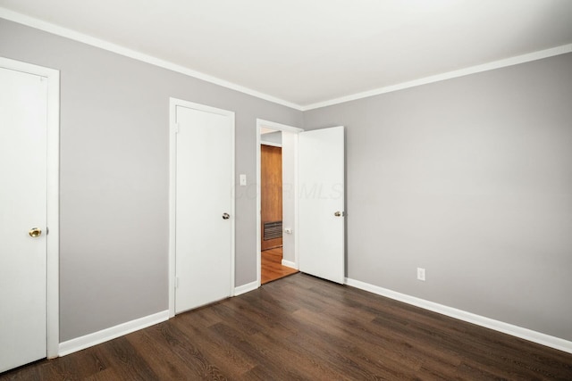 unfurnished bedroom featuring dark hardwood / wood-style floors and ornamental molding