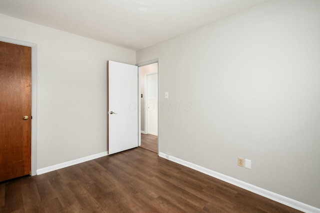 unfurnished bedroom with dark hardwood / wood-style flooring