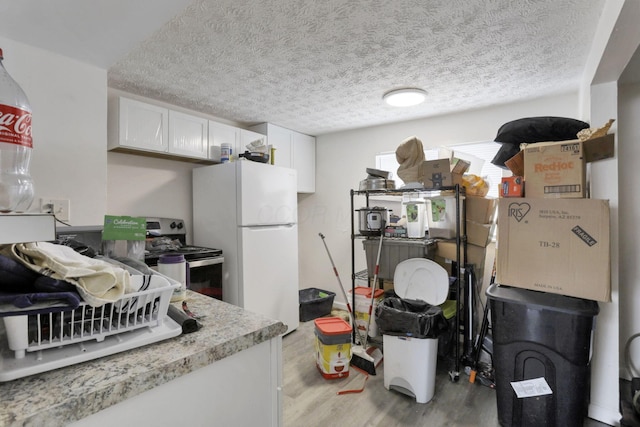 kitchen with electric stove, light hardwood / wood-style flooring, a textured ceiling, white cabinets, and white refrigerator