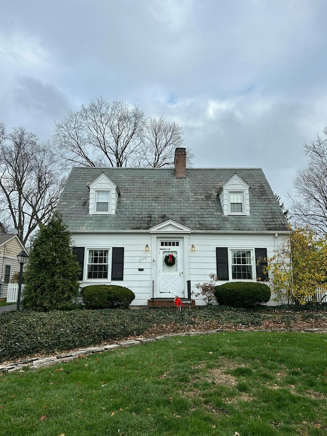 cape cod home featuring a front yard