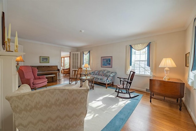 living room with ornamental molding and light hardwood / wood-style flooring