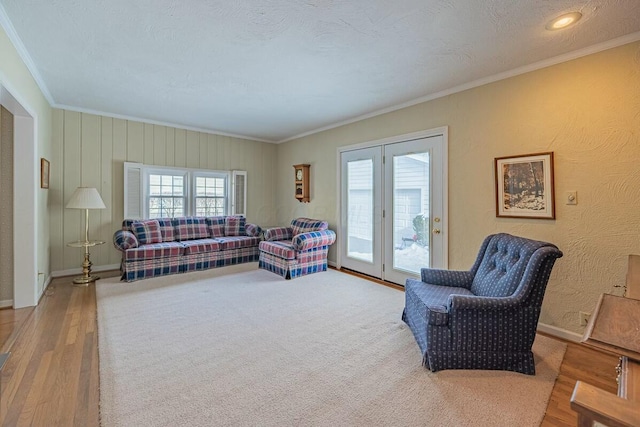 living room with french doors, a textured ceiling, hardwood / wood-style floors, and crown molding