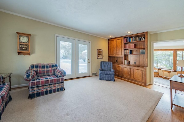 sitting room with light hardwood / wood-style flooring and crown molding