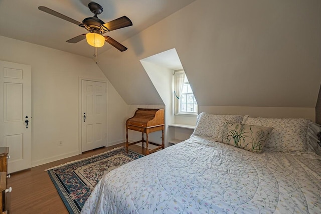 bedroom with dark hardwood / wood-style flooring, ceiling fan, and vaulted ceiling