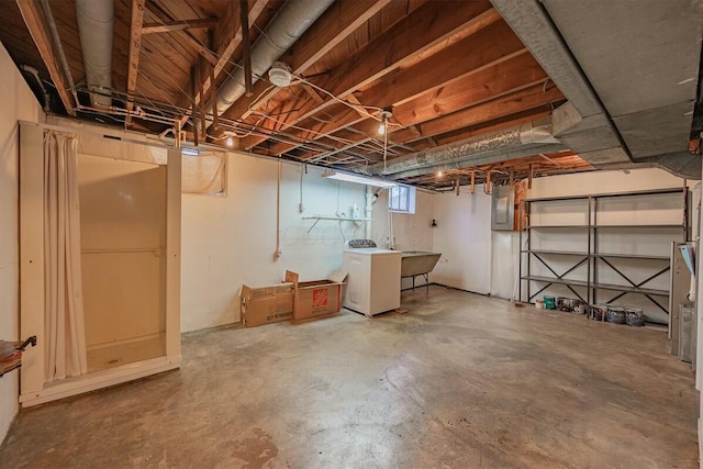 basement featuring washer / dryer, sink, and electric panel