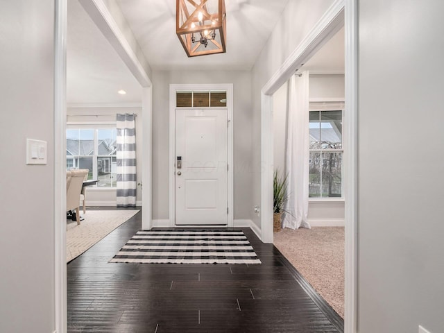 foyer entrance with an inviting chandelier and dark wood-type flooring