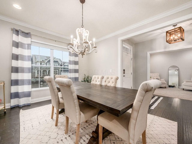 dining space with a chandelier, crown molding, and dark wood-type flooring