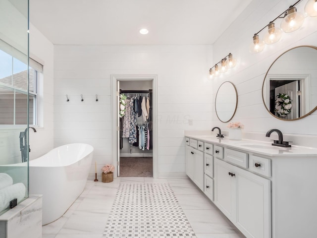 bathroom with a washtub and vanity