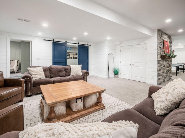 living room featuring a barn door and light colored carpet