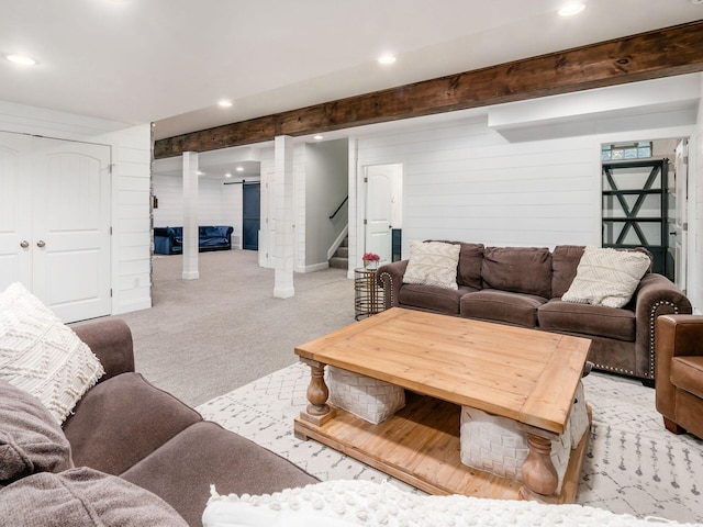 living room featuring light carpet and wood walls