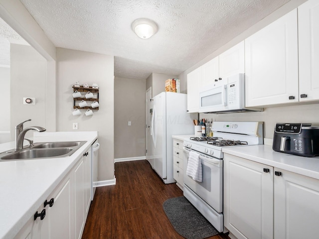 kitchen featuring a textured ceiling, white appliances, dark wood-type flooring, sink, and white cabinetry