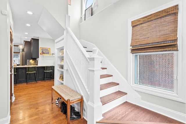 stairs with hardwood / wood-style floors and built in features