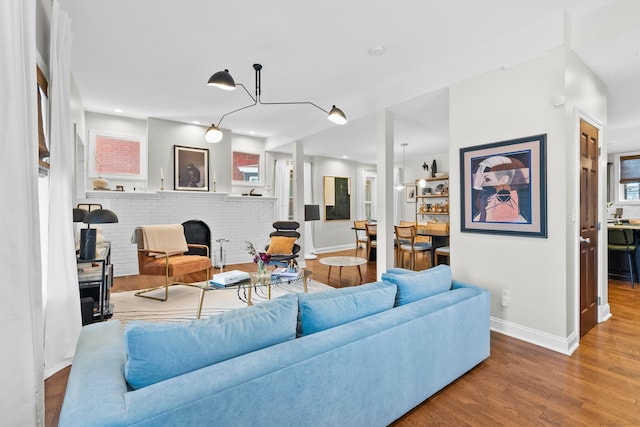 living room featuring hardwood / wood-style floors and a brick fireplace