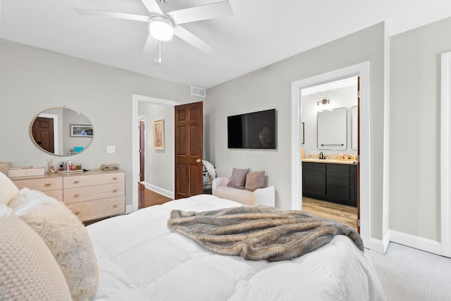 carpeted bedroom featuring connected bathroom, ceiling fan, and sink