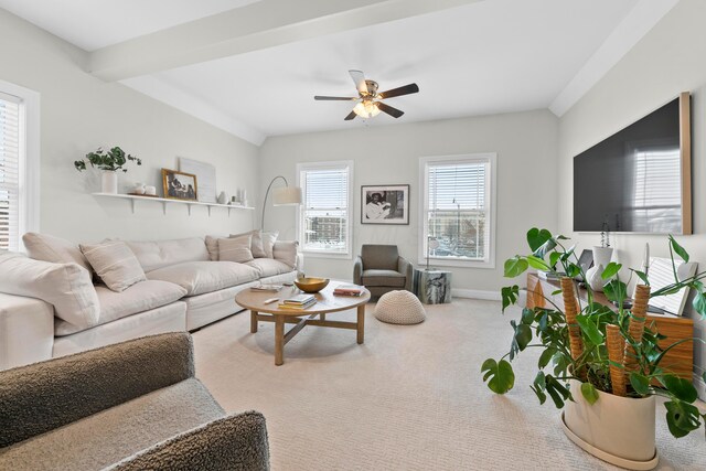 living room with beam ceiling, light colored carpet, and ceiling fan