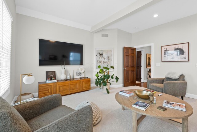 living room featuring carpet floors and beamed ceiling